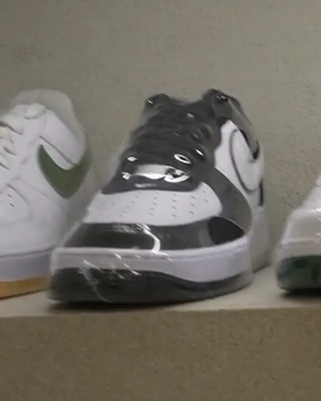 Nike Air Force 1 '07 Cinzento / Branco numa prateleira iluminada