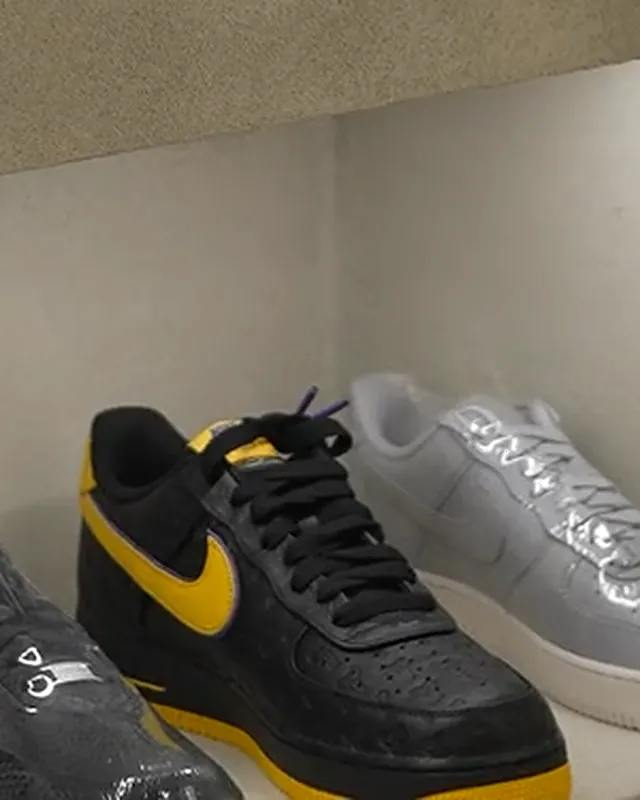 Nike Air Force 1 '07 Preto / Amarelo numa prateleira iluminada
